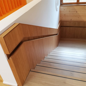 Holztreppe mit Treppenlauf und Antirutschschiene auf den Stufen