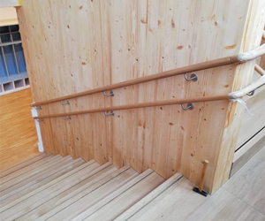Holztreppe mit Treppenlauf und Antirutschschiene auf den Stufen